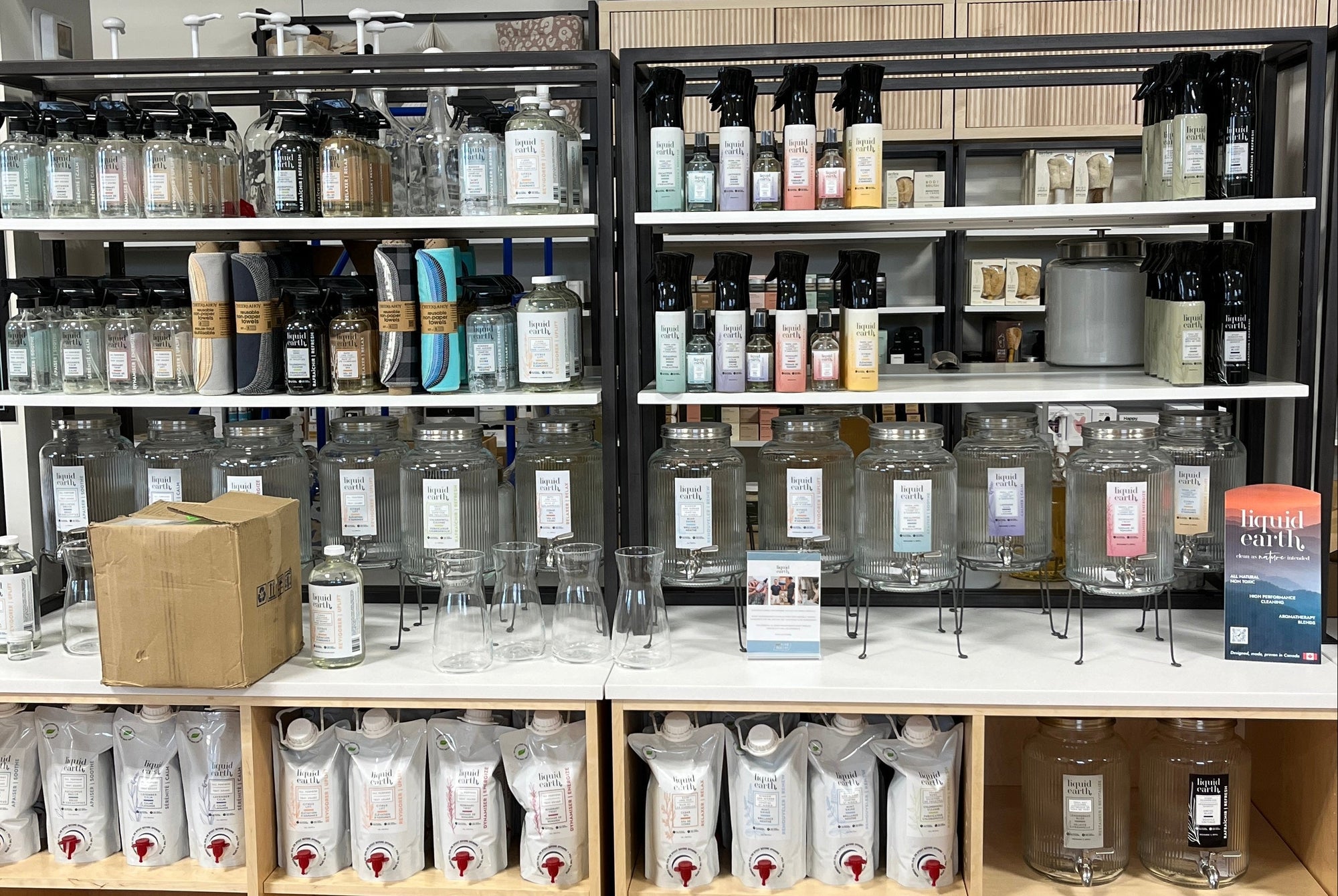 Shelves stocked with various Liquid Earth cleaning products in a store setting.